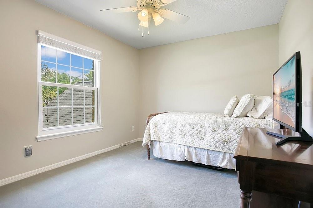 2702 Carter Grove Circle Windermere, FL 34786 - Photo 23 of 42 a bedroom with a bed tv and a window