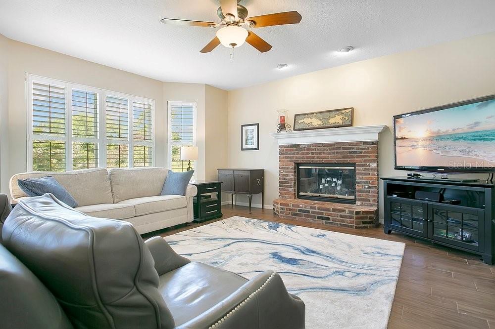 2702 Carter Grove Circle Windermere, FL 34786 - Photo 7 of 42 a living room with furniture a flat screen tv and a fireplace