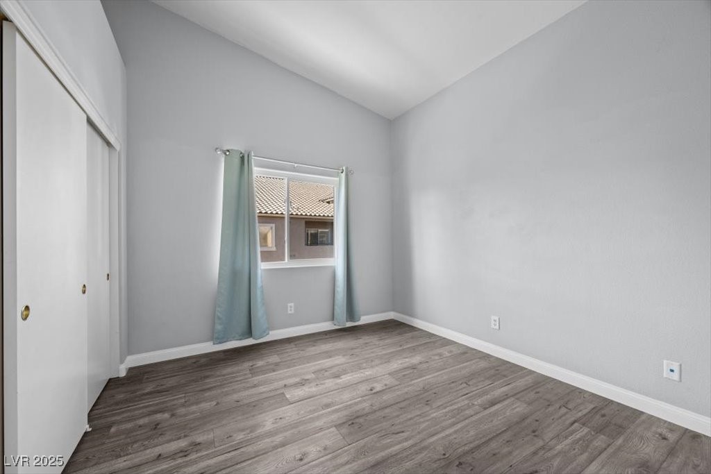 2152 Quarry Ridge Street, Unit 207 Las Vegas, NV 89117 - Photo 27 of 37 Unfurnished bedroom with vaulted ceiling, wood finished floors, and a closet