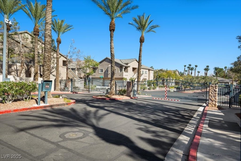 2152 Quarry Ridge Street, Unit 207 Las Vegas, NV 89117 - Photo 35 of 37 View of asphalt road featuring a gate, a residential view, curbs, and a gated entry