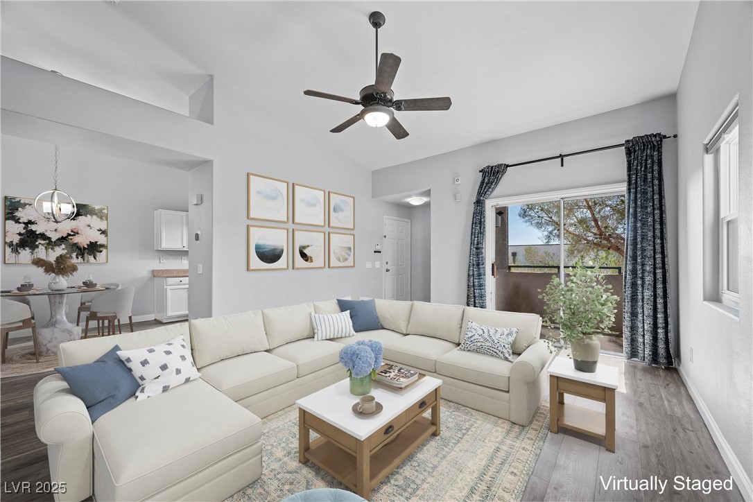 2152 Quarry Ridge Street, Unit 207 Las Vegas, NV 89117 - Photo 5 of 37 "Virtually Staged" Living area featuring wood finished floors, lofted ceiling, a ceiling fan, and a chandelier