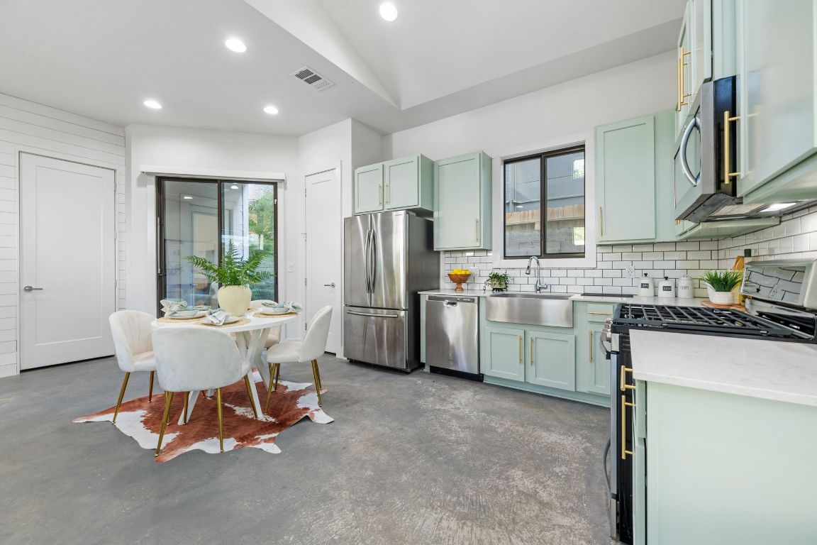 1118 Algarita Avenue, Unit 1 Austin, TX 78704 - Photo 9 of 26 a kitchen with a refrigerator a stove a sink and a dining table with chairs