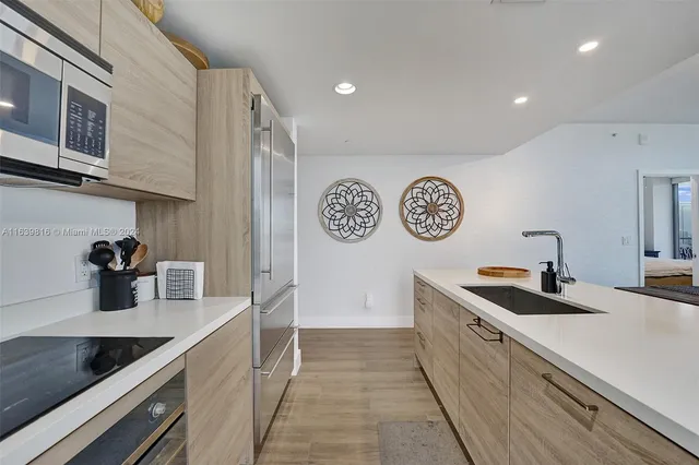 a kitchen with sink refrigerator and microwave