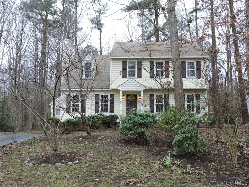 a front view of a residential houses with yard and trees
