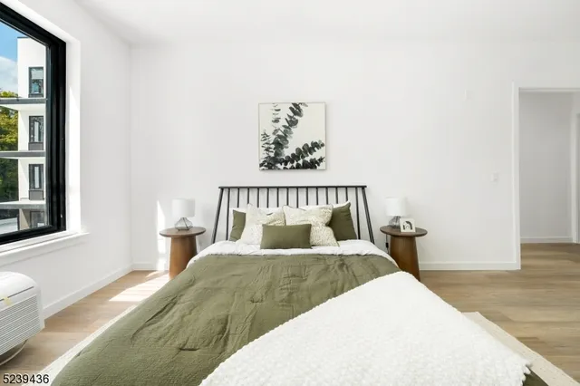 a bedroom with a bed and wooden floor