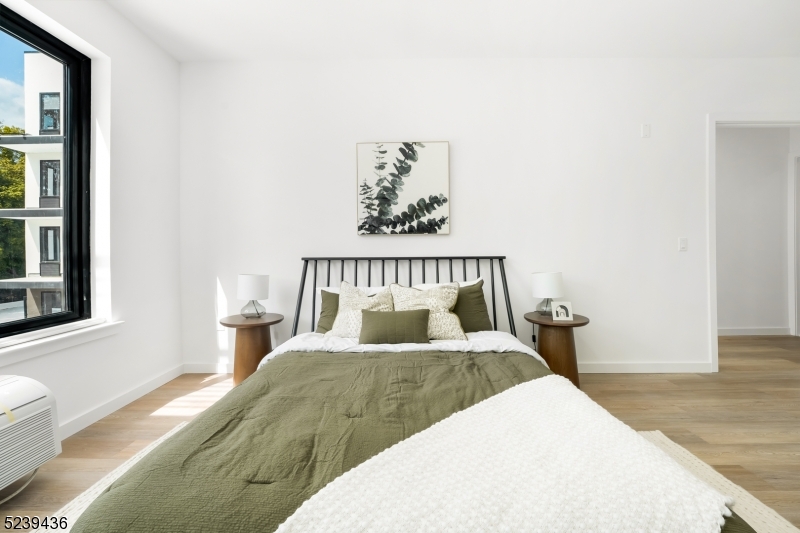 803 South Avenue, Unit 507 Plainfield, NJ 07062 - Photo 23 of 45 a bedroom with a bed and wooden floor