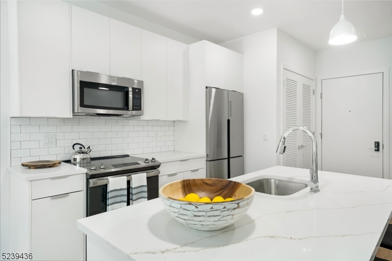 803 South Avenue, Unit 507 Plainfield, NJ 07062 - Photo 3 of 45 a kitchen with stainless steel appliances granite countertop a sink a stove a microwave a refrigerator a refrigerator and cabinets