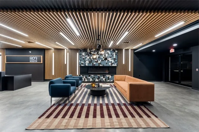 a living room with furniture a fireplace and a chandelier
