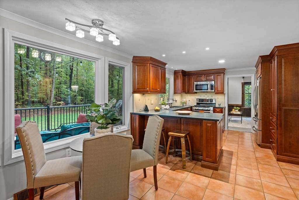 35 Oxbow Lane Groton, MA 01450 - Photo 11 of 34 a kitchen with a table chairs refrigerator and microwave