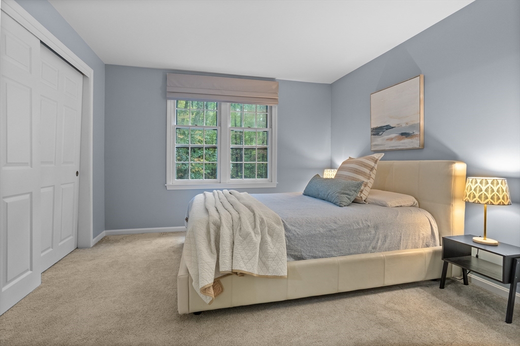 35 Oxbow Lane Groton, MA 01450 - Photo 24 of 34 a bed sitting in a bedroom next to a window
