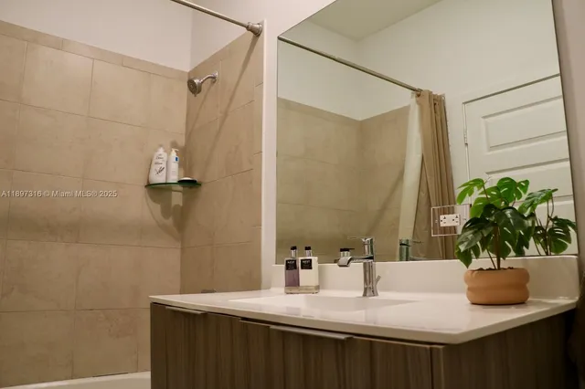 a bathroom with a sink a mirror and a shower
