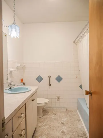 a bathroom with a sink a toilet a mirror and shower