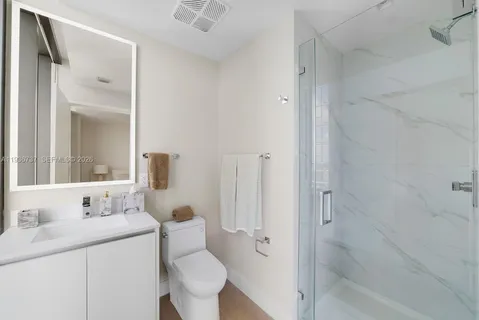 a bathroom with a sink toilet vanity and shower