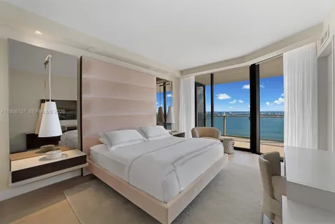 a bedroom with a large bed and a lamp on table