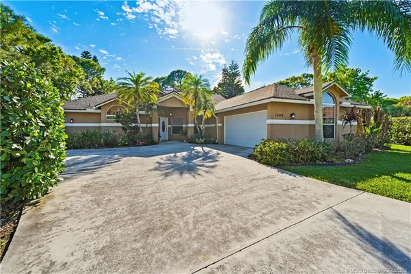 a front view of a house with a yard and potted plants