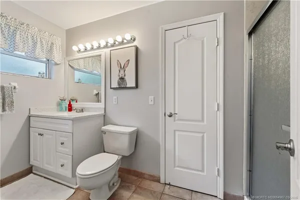 a bathroom with a toilet sink vanity and mirror