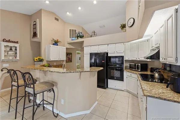 a kitchen with stainless steel appliances granite countertop a refrigerator and a stove top oven