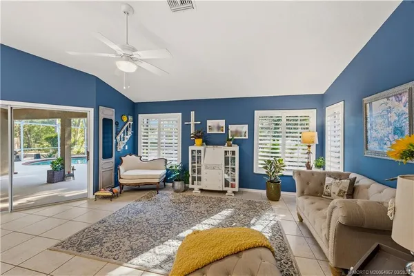 a living room with furniture and floor to ceiling windows