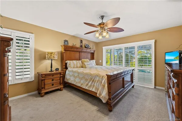 a bed sitting in a spacious bedroom next to a window