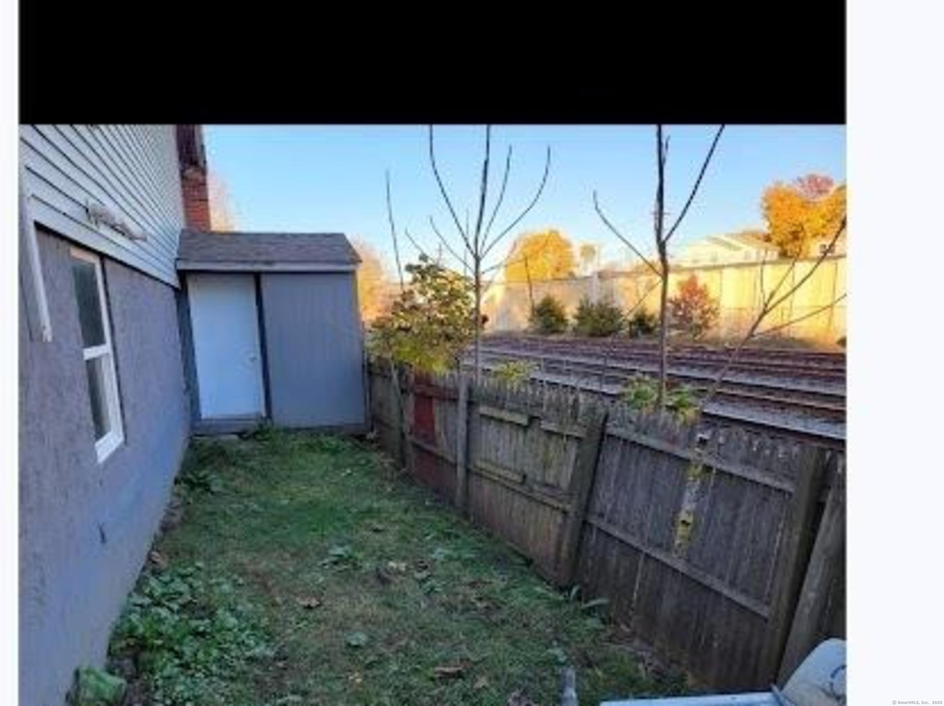 387 Colony Street Meriden, CT 06451 - Photo 2 of 8 a view of a backyard with wooden fence