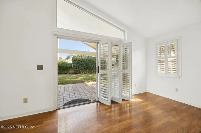 a view of empty room with wooden floor