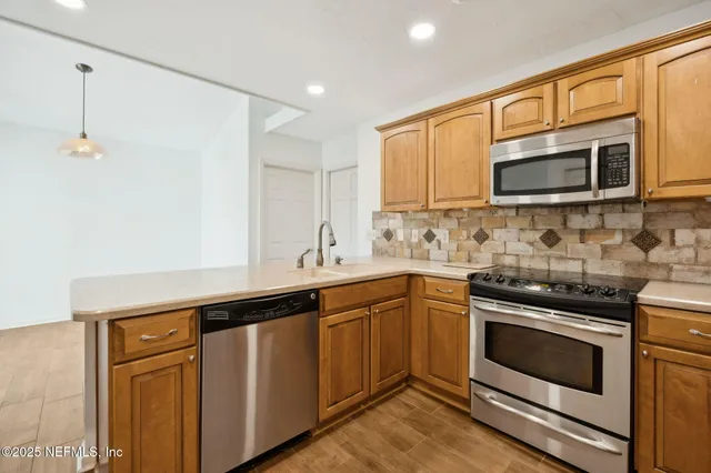 a kitchen with cabinets stainless steel appliances and a window