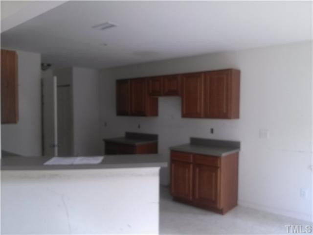 2817 Filbert Street Raleigh, NC 27610 - Photo 5 of 11 View of kitchen from living room. Dark cabinets and counter tops add some character to kitchen.