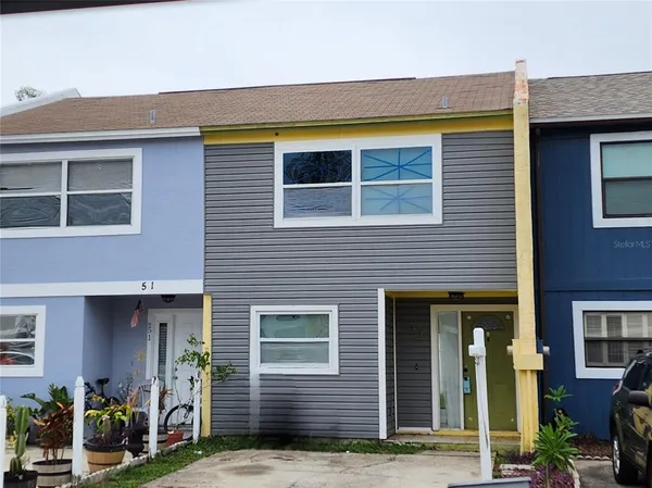 a view of brick house with potted plants and a table and chairs
