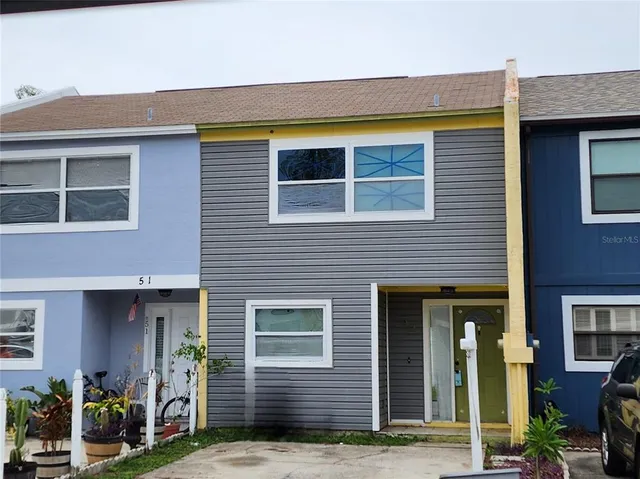 a view of brick house with potted plants and a table and chairs