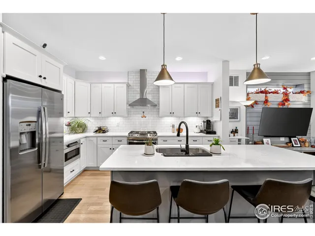 a open kitchen with stainless steel appliances kitchen island granite countertop a sink a stove a dining table and chairs