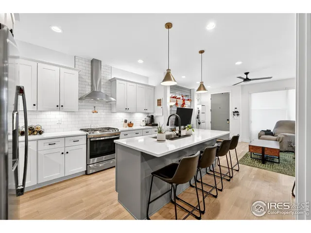 a kitchen with stainless steel appliances a stove and white cabinets