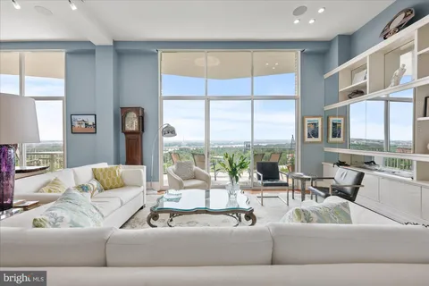 a living room with furniture and large windows