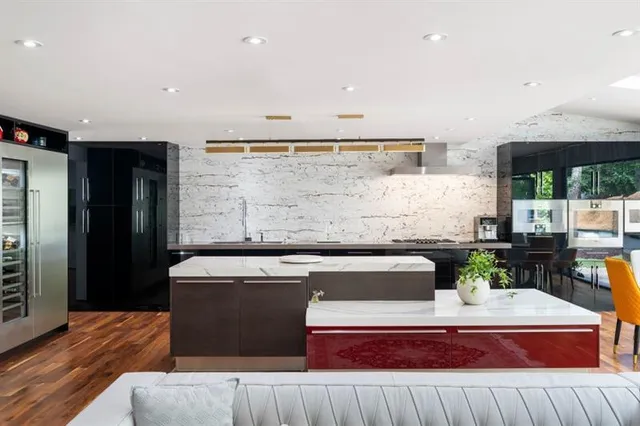 a living room with stainless steel appliances kitchen island granite countertop furniture and a wooden floor
