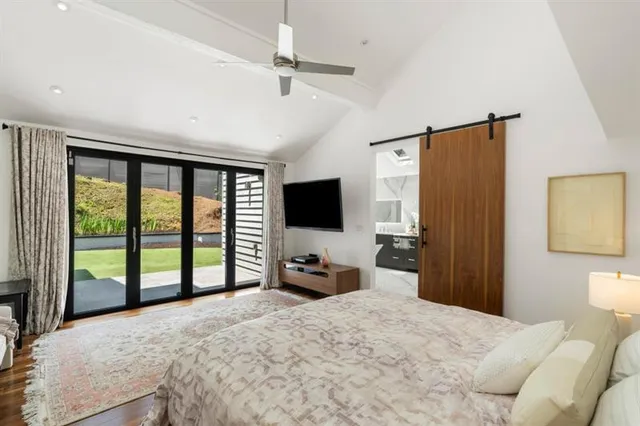 a bedroom with a large bed and a flat tv screen