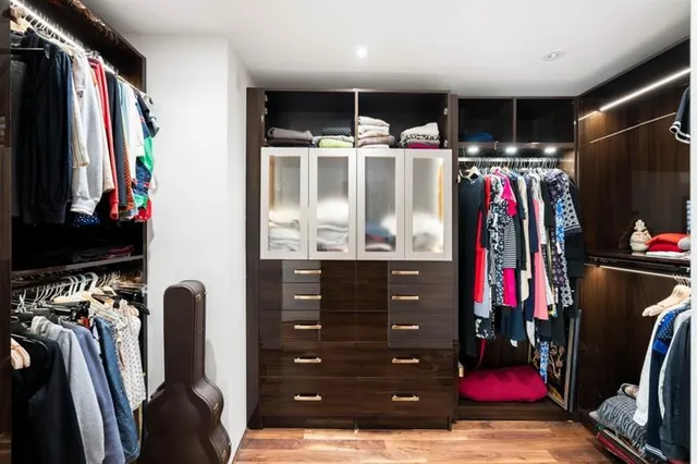 a view of walk in closet with clothes and shoes