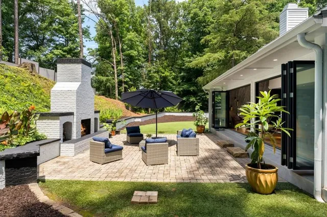 a view of a patio with couches table and chairs under an umbrella