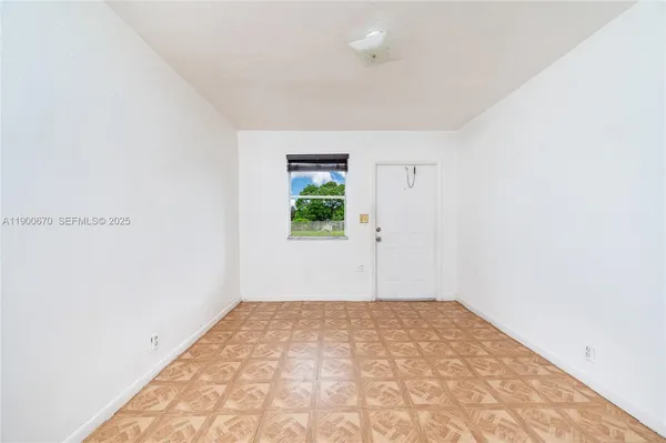 a view of a bedroom with wooden floor and window