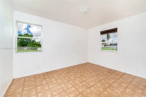 a view of a bedroom with wooden floor and a window