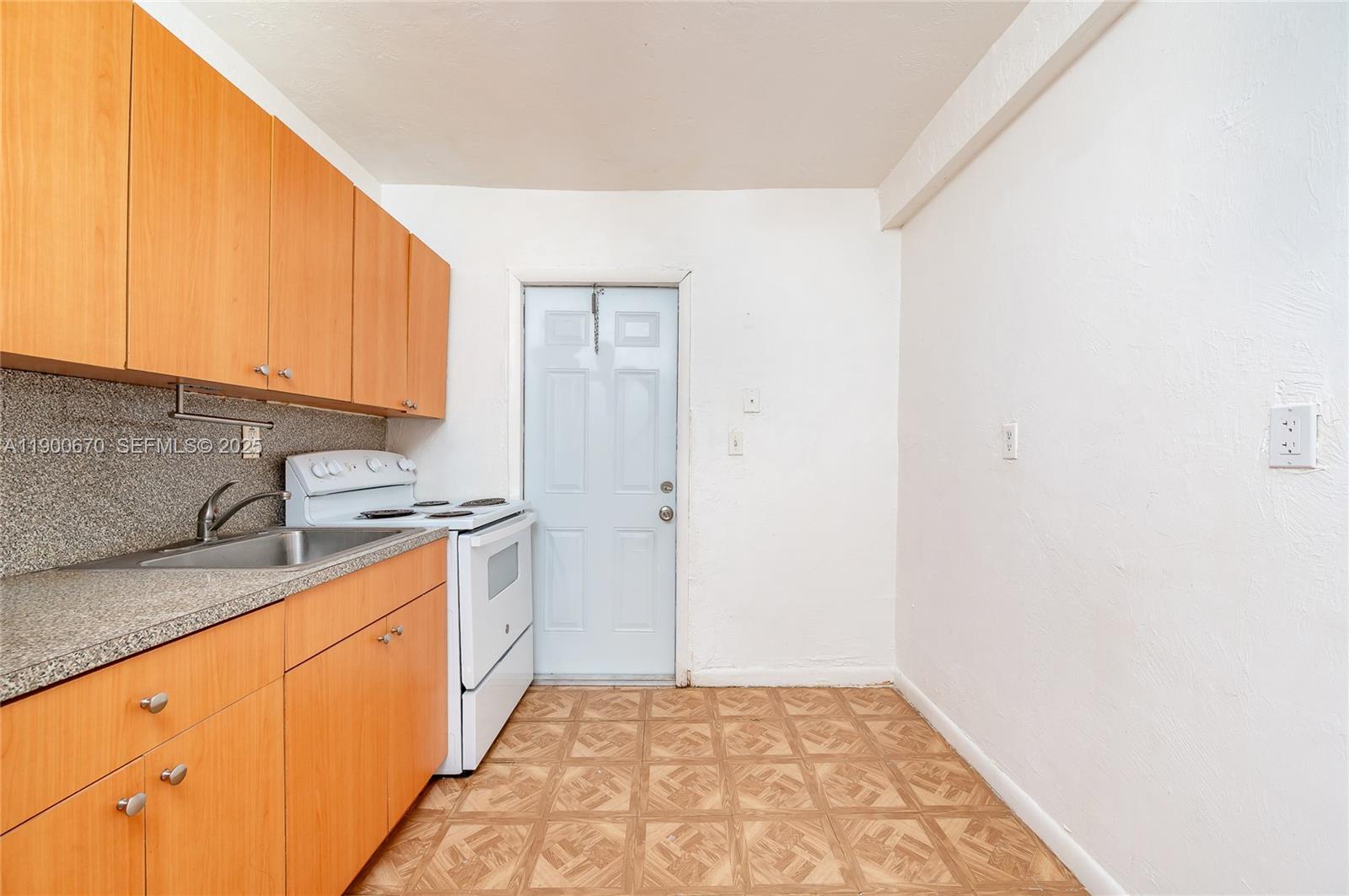 10015 Southwest 170th Terrace, Unit 2 Miami, FL 33157 - Photo 8 of 26 a kitchen with a sink a stove top oven and cabinetry