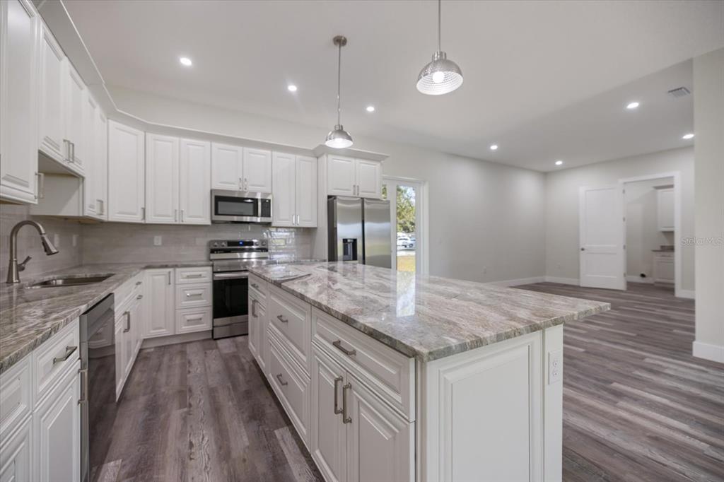 3525 McIntosh Road Sarasota, FL 34232 - Photo 13 of 40 a kitchen with kitchen island granite countertop a sink a counter top space appliances and cabinets