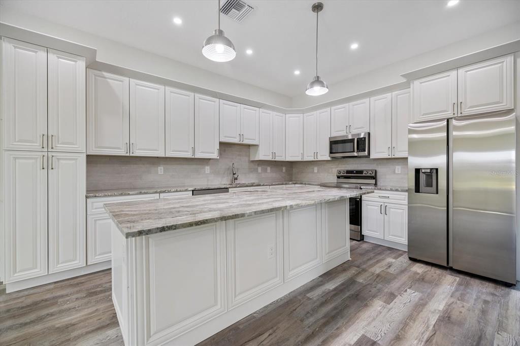 3525 McIntosh Road Sarasota, FL 34232 - Photo 9 of 40 a kitchen with a refrigerator a sink and dishwasher with wooden floor