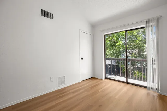 a view of a room with wooden floor and a window