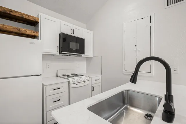 a kitchen with stainless steel appliances kitchen island a white stove top oven and sink