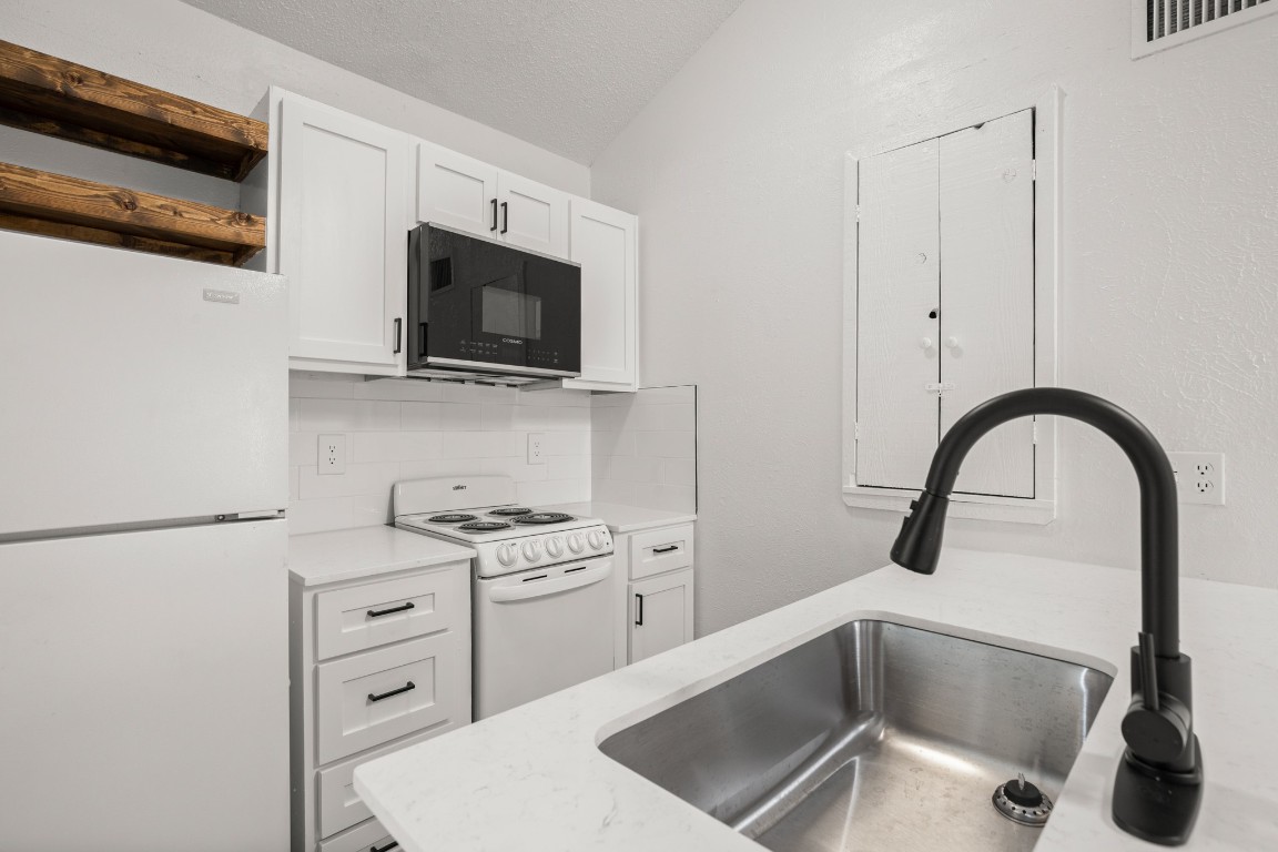 4205 Speedway, Unit 301 Austin, TX 78751 - Photo 6 of 19 a kitchen with stainless steel appliances kitchen island a white stove top oven and sink