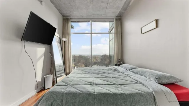a bedroom with a bed tv and a window