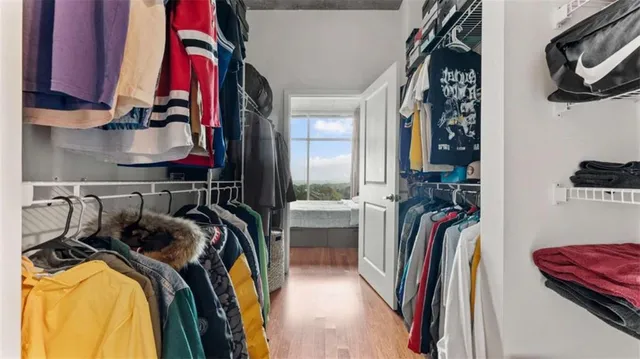 a view of walk in closet with clothes and shoes