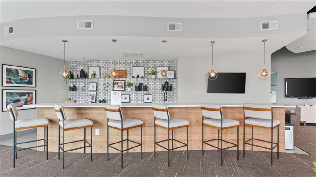 250 Pharr Road Northeast, Unit 712 Atlanta, GA 30305 - Photo 19 of 34 a kitchen with stainless steel appliances kitchen island granite countertop a table and chairs in it