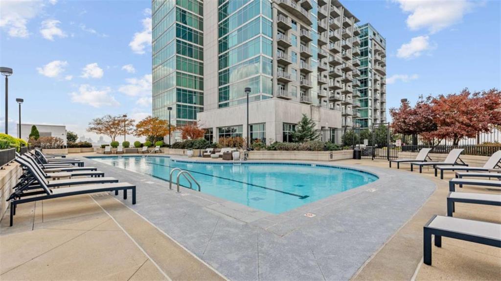 250 Pharr Road Northeast, Unit 712 Atlanta, GA 30305 - Photo 31 of 34 a swimming pool with outdoor seating and city view