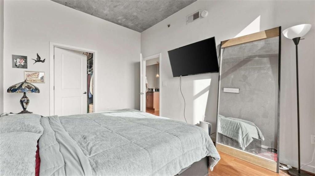 250 Pharr Road Northeast, Unit 712 Atlanta, GA 30305 - Photo 8 of 34 a bedroom with a bed and a flat screen tv