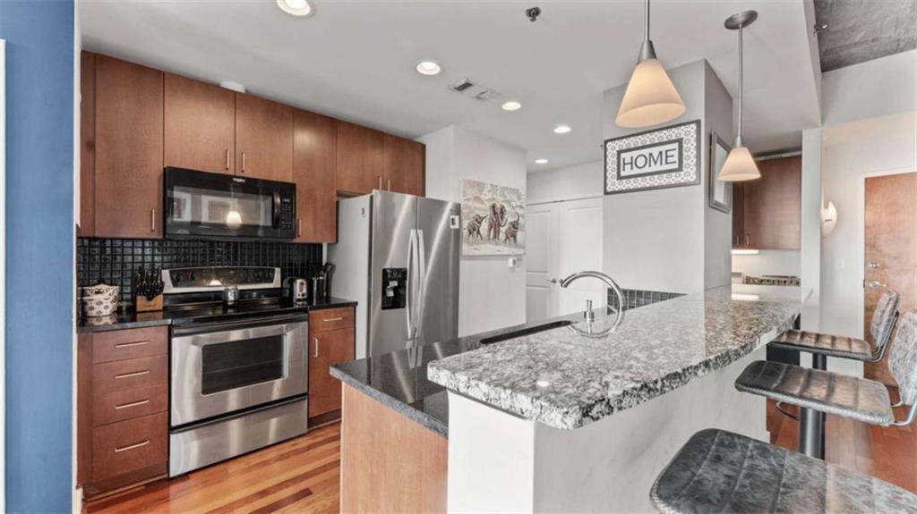 250 Pharr Road Northeast, Unit 712 Atlanta, GA 30305 - Photo 10 of 34 a kitchen with stainless steel appliances granite countertop a sink stove and refrigerator
